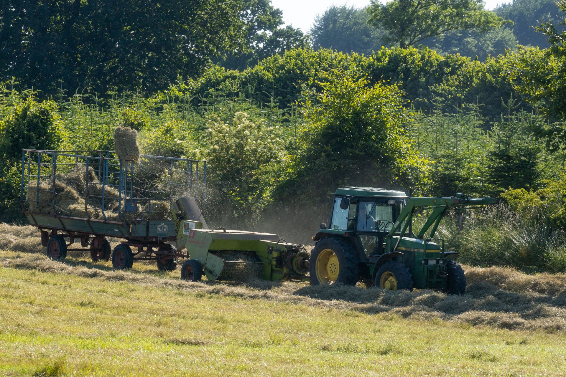 Tractor and agricultural equipment working in a green field